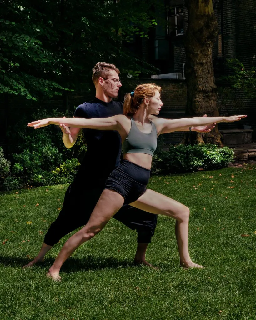 Instructor adjusting a student in warrior two outdoors